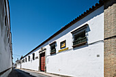 Located in Barrio Alto, this stunning white-walled winery showcases Sanlucar de Barrameda's architecture beneath a clear sky.