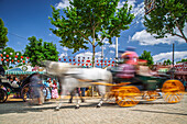 Seville, Spain, Apr 29 2009, Horse-drawn carriages glide through the vibrant Seville Fairgrounds during April's Fair, capturing the festive spirit of Andalusia.