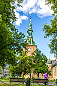 Oslo, Norway, Aug 10 2017, The striking bell tower of Oslo Cathedral rises above lush greenery on a sunny day in Norway, capturing the charm of the city.
