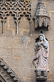 The elegant sculpture of La Virgen Maria adorns the Mudejar facade of San Marcos church in Seville, showcasing rich history and artistry.