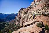 Young caucasian man in canyon overlook trail, admiring the landscape view, Zion National Park, Utah