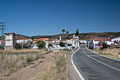 The approach to Pallares village showcases typical Mediterranean architecture under a clear blue sky, inviting exploration of the area.