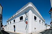 White-walled winery stands prominently on Cuna Street in the Barrio Alto of Sanlucar de Barrameda, capturing Andalusian heritage and charm.