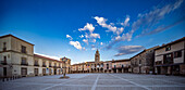 Visitors stroll through the tranquil Plaza Mayor in Medinaceli, Soria, enjoying the peaceful atmosphere and stunning architecture.