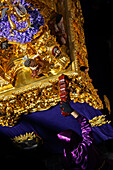 Historical Holy Week celebration featuring a penitent and the Cigarreras brotherhood's paso float.