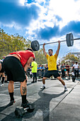 Seville, Spain, Nov 9 2024, Competitors showcase their strength during a Crossfit event in Seville, Spain, under a clear sky, engaging the audience.