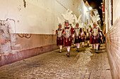 Seville, Spain, Apr 2 2010, Los Armaos, part of the Roman Centuria Macarena, march through a narrow street in Seville during the evening of Holy Thursday.