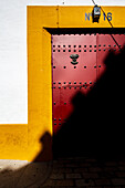 This entrance leads matadors to the crew area of the historic Real Maestranza bullring in Seville, showcasing vibrant colors and shadows.