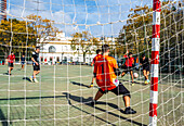 Sevilla, Spanien, 9. November 2024, Jugendliche spielen Futsal im Freien unter der strahlenden Sonne in einer malerischen Gegend von Sevilla.