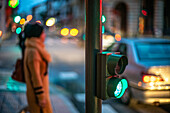 Bright green traffic light at night with out-of-focus urban background in Seville.