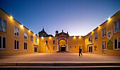 Seville, Spain, July 26 2022, Visitors explore the vibrant courtyard of CAAC, a former convent, as twilight sets in. The yellow walls showcase contemporary works.
