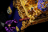 Historical Holy Week celebration featuring a penitent and the Cigarreras brotherhood's paso float.