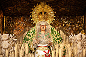 Virgin of Esperanza Macarena on her float surrounded by candles during the solemn conclusion of Good Friday procession in Seville.