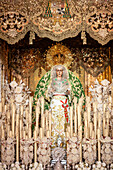 Virgin of Esperanza Macarena on her float surrounded by candles during the solemn conclusion of Good Friday procession in Seville.