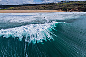 Aerial drone view of Big wave surfing in Praia do Norte (North Beach), listed on the Guinness World Records for the biggest waves ever surfed, formed under the influence of the Nazare Canyon, Portugal