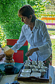 A woman brews coffee in a pour over drip coffee maker during a tour of a coffee farm in Colombia.