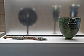 A dagger & wine cup in the Vesuvian Life Gallery, National Archaeological Museum of Naples, Naples, Italy. From the Gladiatorial Barracks in Pompeii, circa 1st Century A.D. The wine cup has small figures of gladiators on it. The dagger sheath is made of silver and wood.