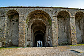 Tourists in the entrance tunnel of the Amphitheater of Pompeii in the ancient Roman ruins of Pompeii in Italy.