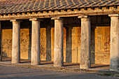 The colonnaded facade of the Stabian Baths, Building VII.1.8, in the ancient Roman ruins of Pompeii, Italy.