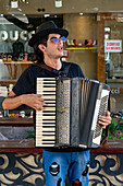 A street musician or busker playing the accordian for tips on a street in Santiago del Estero, Argentina.