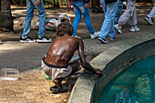 A homeless person washing himself in a fountain in Bolivar Park in Medellin, Colombia.