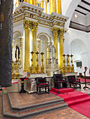 Large gold candlesticks in front of the main altarpiece in the Basilica of Our Lady of Candelaria, Medellin, Colombia.