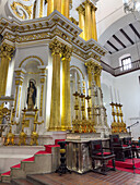 Large gold candlesticks in front of the main altarpiece in the Basilica of Our Lady of Candelaria, Medellin, Colombia.