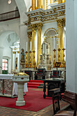 Large gold candlesticks in front of the main altarpiece in the Basilica of Our Lady of Candelaria, Medellin, Colombia.
