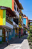 Colorfully-painted buildings along a cobblestone street in the tourist town of Guatape, Colombia.