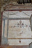 Colorful frescoes in the House of the Lararium of Achilles, Building I.6.4, in the ancient Roman ruins of Pompeii, Italy.