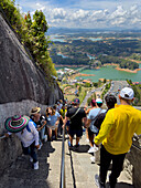 Touristen, die die 740 Stufen zum Gipfel des Piedra del Penon oder Penon de Guatape in der Nähe von Guatape, Kolumbien, hinauf- und hinabsteigen.