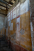 Colorful frescoes in the House of the Lararium of Achilles, Building I.6.4, in the ancient Roman ruins of Pompeii, Italy.
