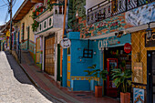 Colorfully-painted buildings along a cobblestone street in the tourist town of Guatape, Colombia.