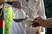 Eine Frau brüht Kaffee aus einer Siphon-Kaffeemaschine während der Besichtigung einer Kaffeefarm in Kolumbien.