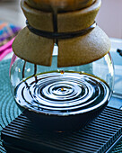 Coffee drops falling in a pour over drip coffee maker brewing coffee during a tour of a coffee farm in Colombia.