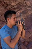 A young indigenous man plays a llama-shaped ocarina at the Amphitheater in Quebrada de las Conchas, Argentina.