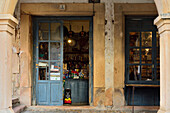 Old shop with blue door under the arcades of Sancho García Street in Sepúlveda, Segovia.