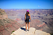 Standing young woman enjoying the views of Grand Canyon, Arizona
