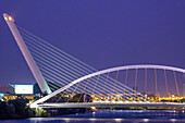 The illuminated Barqueta and Alamillo bridges enhance Seville's skyline, showcasing elegance and serenity at twilight.