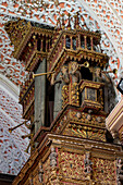 The ornately-carved pipe organ in the Basilica of Our Lady of Mercy in Quito, Ecuador. Decorated with angels blowing trumpets.