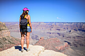 Standing young woman enjoying the views of Grand Canyon, Arizona