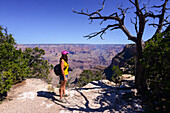 Standing young woman enjoying the views of Grand Canyon, Arizona