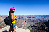 Standing young woman enjoying the views of Grand Canyon, Arizona