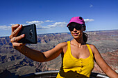 Young caucasian woman taking a selfie in Grand Canyon viewpoint, Arizona