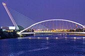 The illuminated Barqueta and Alamillo bridges enhance Seville's skyline, showcasing elegance and serenity at twilight.