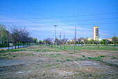 Torre Sevilla towers at dusk, surrounded by the peaceful landscape of Vega de Triana park, offering a serene evening ambiance.