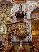 The ornately-carved pulpit in the nave of the Basilica of Our Lady of Mercy, Quito, Ecuador.