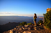 Young woman enjoying the sunset views from Grand Canyon Desert View Watchtower, Arizona