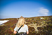 Rear view of girl standing on field in winter