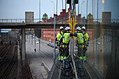 Arbeiter im seilunterstützten Zugang, stehend auf einem Bauwerk außerhalb eines Gebäudefensters